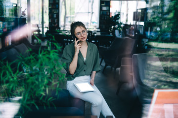 Fototapeta na wymiar Female worker talking on smartphone sitting in office