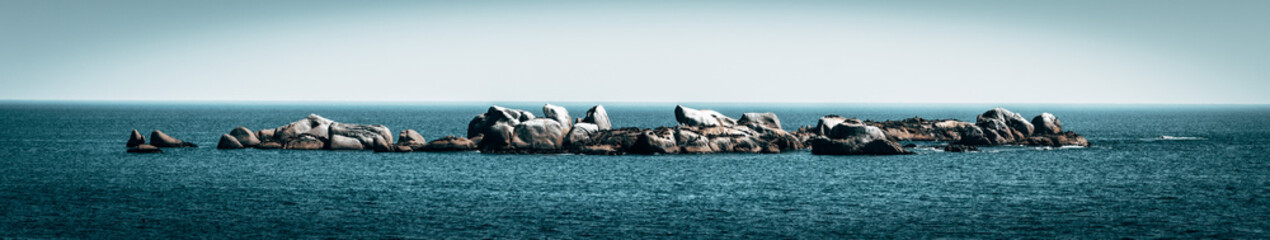 A panoramic landscape of a rocky outcrop in the ocean