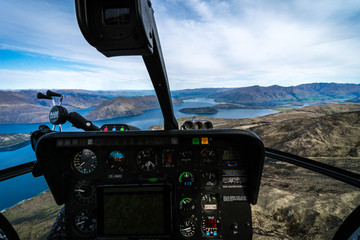 Stunning helicopter cockpit image with Wanaka lake in the background on a sunny winter day, New Zealand