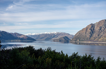 Beautiful sunset panorama at Hawea lake with snow capped mountains in the background on a winter day, New Zealand