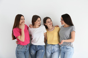 Beautiful young ladies in jeans and colorful t-shirts on white background. Woman's Day