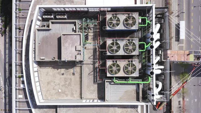 Aerial view of a large office building roof with various ventilation engine and systems running.