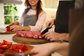 People cooking food together in kitchen, closeup