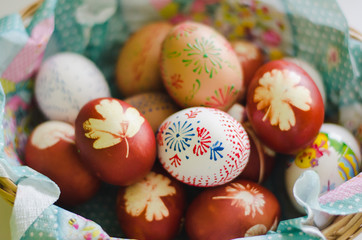 Colorful easter eggs in a basket. Colors made with natural ingredients and painted with wax. One of the easter tradition in Czech republic. Detailed view