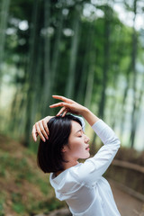 Fototapeta premium Young Asian women in bamboo forest