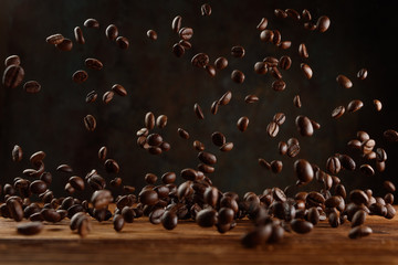 Many roasted coffee beans flying in the air. Selective focus