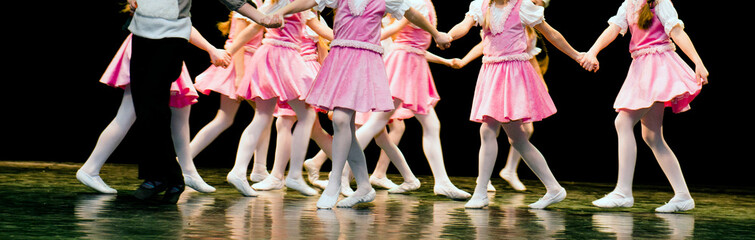 Children dance on stage in elegant clothes

