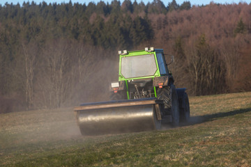 Fototapeta premium a tractor on a meadow in the evening