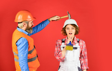 Intelligibly concept. Couple renovating apartment together. Man and woman wear safety helmet....