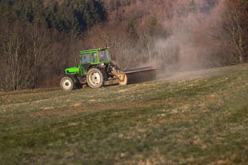 Fototapeta premium a tractor on a meadow in the evening