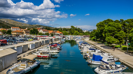 Widok na kanał w centrum miasta Trogir w Chorwacji z pięknym krajobrazem w tle. - obrazy, fototapety, plakaty