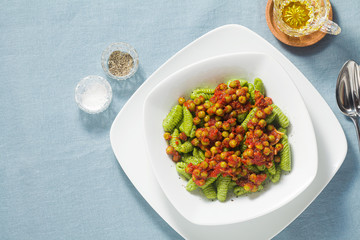 Italian fresh traditional sardinian pasta gnocchi with spinach and green pea tomato sauce. spring pasta for easter holidays.