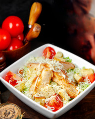 caesar salad topped with fried chicken and cheese