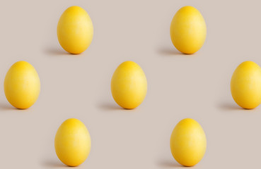 egg pattern on pastel background. Copy space with yellow easter eggs on beige background