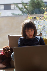 bored city child hypnotized by computer for lockdown homeschool learning