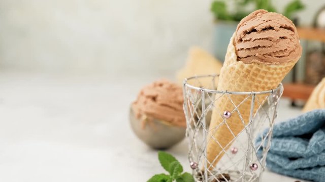 Delicious summer dessert coffee ice cream in waffle cone. Summertime healthy food concept, lactose free. Camera slide right