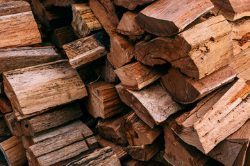 Close-up photo of firewood stacked into a neat pile. Firewood stacked ready for use in a fireplace in winter.