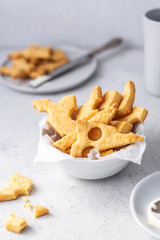 Cheese crackers, salty snack concept. Cookies, piece of cheese on a gray background