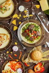 slow cooked pulled beef with fresh vegetable salad close-up on a plate. flat lay, shot from above on a black background