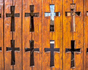 Wooden fence with christian crosses carved in it. Fence of a orthodox church in Romania.