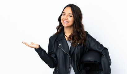 Young woman holding a motorcycle helmet over isolated white background holding copyspace imaginary...