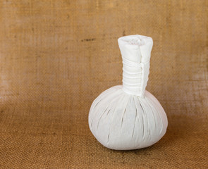 Handmade herbal massage ball on hessian fabric background, Thai style herbal hot ball massage