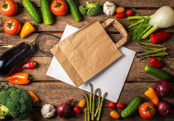 Exposition of fresh organic vegetables on wooden table. tomato, pepper, broccoli, onion, garlic, cucumber,  eggplant, black Eyed Peas, ecological bag.