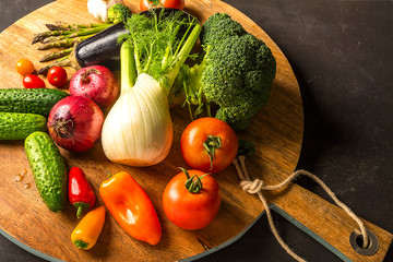 Exposition of fresh organic vegetables on wooden plate. tomato, pepper, broccoli, onion, garlic, cucumber,  eggplant, black Eyed Peas, ecological bag.
