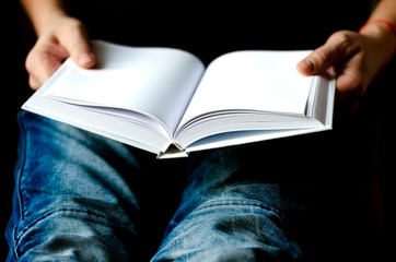 Men's hands hold a white book with clean pages