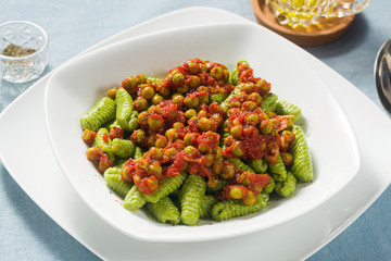 Italian fresh traditional sardinian pasta gnocchi with spinach and green pea tomato sauce. spring...