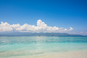 amazing landscape on the beach with sand and blue sky and little clouds in trawangan island in indonesia