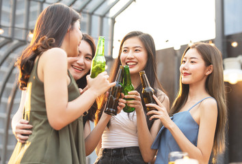 happy asian women holding bottle of beer chat together