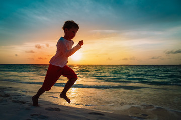 Fototapeta na wymiar happy little boy run on sunset beach