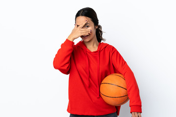 Young woman playing basketball over isolated white background covering eyes by hands and smiling
