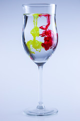 Color ink in glass with water. Food color, red and yellow.