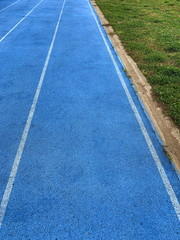 Fototapeta premium blu running racetrack in the grass field