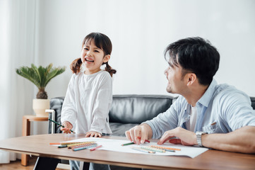 Father and daughter at home painting