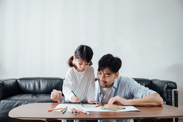 Father and daughter at home painting
