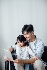 Father and daughter at home using a Tablet PC