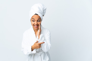Young woman in bathrobe over isolated white background pointing to the side to present a product...