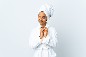 Young woman in bathrobe over isolated white background scheming something