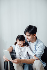 Obraz premium Father and daughter at home using a Tablet PC