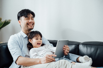 Father and daughter at home using a Tablet PC