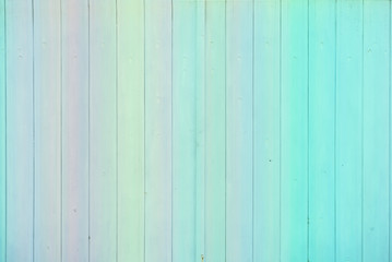 Colorful fence made of painted wooden planks with gradient effect. Colored panel wall