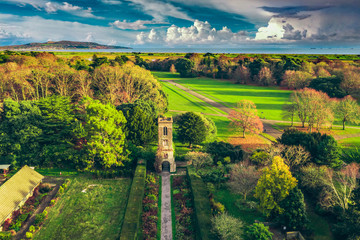 Aerial view over the St. Anne Park, revealing the old tower and the Howth peninsula on the horizon.  Autumn Irish landscape in November.