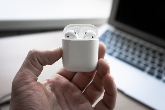 Hand holding the Apple Airpods case