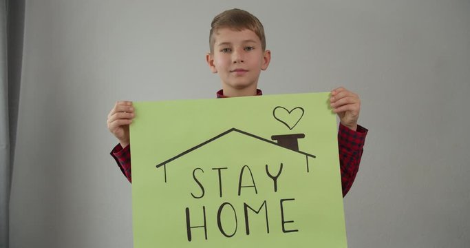 coronavirus quarantined boy holds a sign stay home save lives
