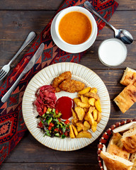 fried cutlets and potato with herbs and side soup