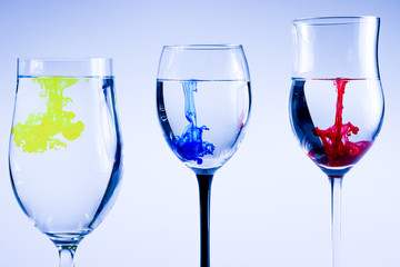 Three glasses whit ink drops. Color splash in water, isolated