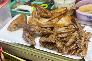 Asian fast food closeup pile of cooked duck neck and head.